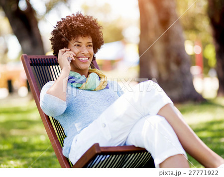 Charming young woman in summer park with mobile Charming young woman in summer park with mobile 27771922