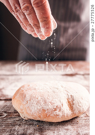 Baker hand sprinkling flour on fresh warm bread Baker hand sprinkling flour on fresh warm bread 27775526
