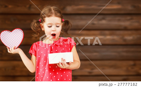 happy laughing child girl with gift Valentine's Day, wooden 27777182