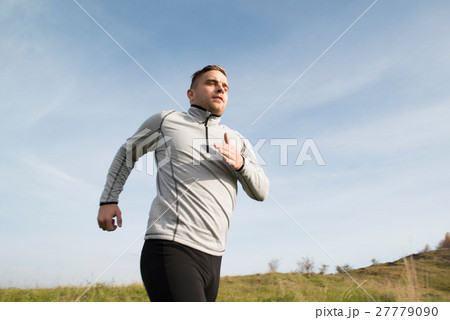 Young handsome hipster athlete running in sunny 27779090