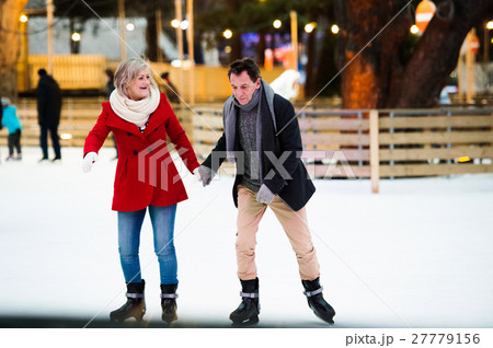 Beautiful senior couple ice skating in city centre Beautiful senior couple ice skating in city centre 27779156