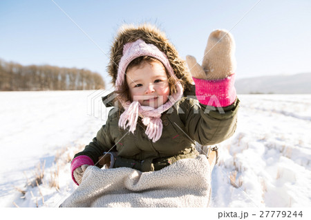 Cute little girl outside in winter nature, sitting Cute little girl outside in winter nature, sitting 27779244