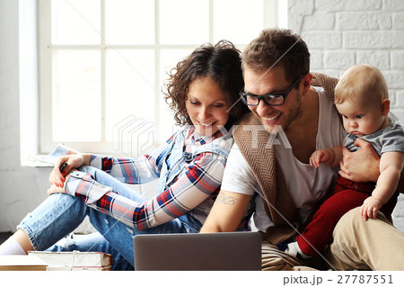 Young happy family relaxing at home on the floor 27787551