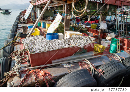 Fishing boat and its drying fish under the sun 27787789