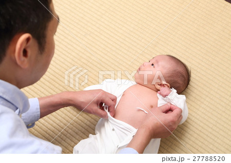 赤ちゃんと着替えをさせる父親 赤ちゃんと着替えをさせる父親 27788520