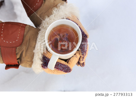 Female hands in knitted grey mittens hold white cup of black spi 27793313