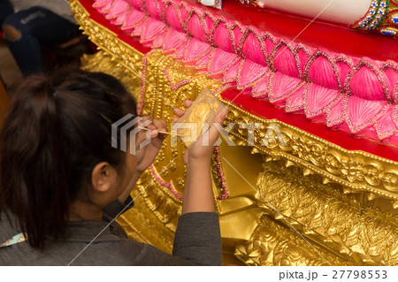 Woman painting buddha statue in gold color Woman painting buddha statue in gold color 27798553