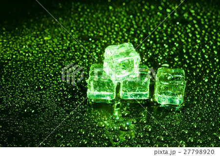 Ice cubes in green light on black wet table. Ice cubes in green light on black wet table. 27798920