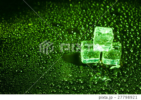 Ice cubes in green light on black wet table. Ice cubes in green light on black wet table. 27798921