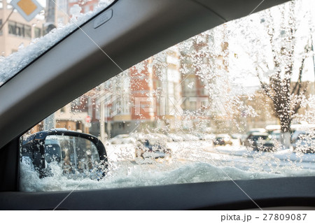 Droplets and snowflakes on car window 27809087