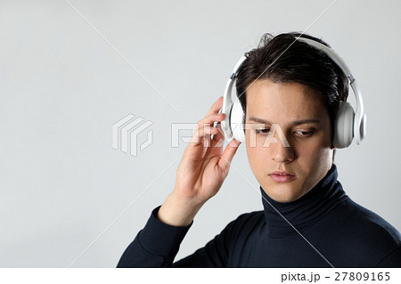 ワイヤレスヘッドホンで音楽を聴く男性の写真素材