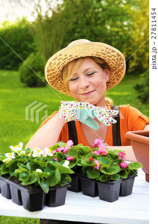 Young woman planting flower seedlings, gardening Young woman planting flower seedlings, gardening 27811454