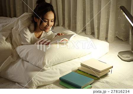 布団の中で読書をする女の子 27816234