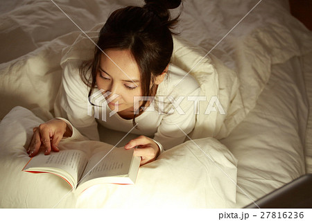 布団の中で読書をする女の子 27816236