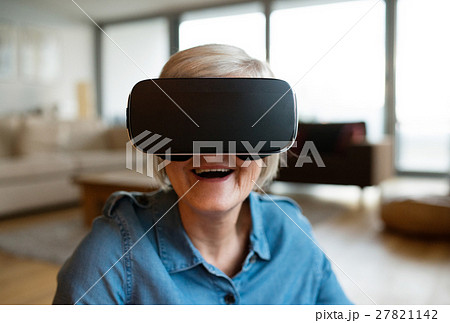 Senior woman wearing virtual reality goggles at Senior woman wearing virtual reality goggles at 27821142