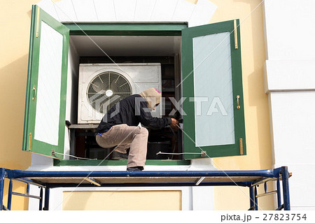 Man painting building window with paint prush 27823754