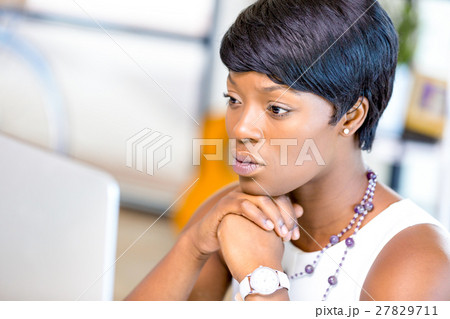 Young businesswoman sitting at desk and working Young businesswoman sitting at desk and working 27829711