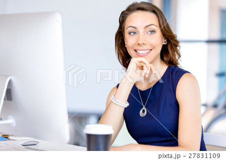 Young businesswoman sitting at desk and working 27831109
