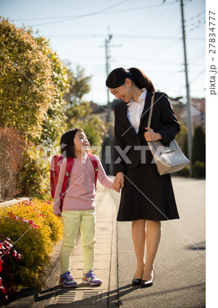 手をつないで歩くワーキングマザーと小学生の女の子 手をつないで歩くワーキングマザーと小学生の女の子 27834777