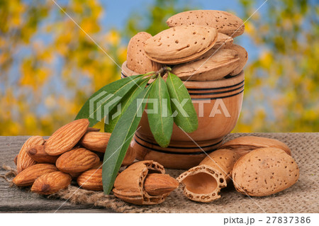 almonds with leaves in a bowl on the old wooden almonds with leaves in a bowl on the old wooden 27837386