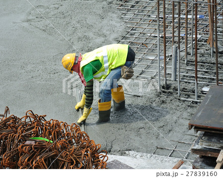 Construction workers leveling wet concrete Construction workers leveling wet concrete 27839160