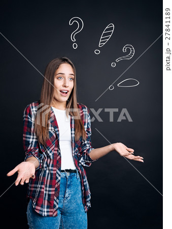 Puzzled woman standing on black background 27841189