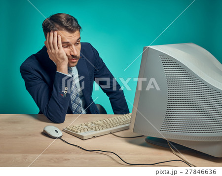 Sad Young Man Working On computer At Desk 27846636