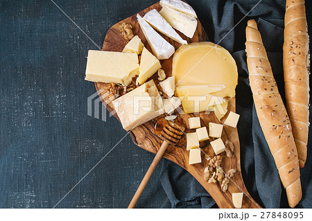 Assortment of cheese on wooden board 27848095