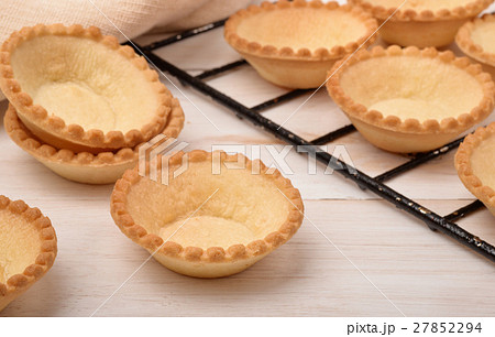 Group of fresh baked empty tart shells Group of fresh baked empty tart shells 27852294