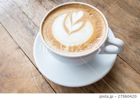Cup of coffee with heart pattern in a white cup on wooden background Cup of coffee with heart pattern in a white cup on wooden background 27860420