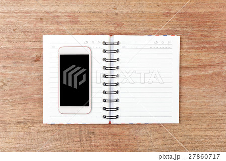 Top view of Open Notebook and smart phone on wood table for background Top view of Open Notebook and smart phone on wood table for background 27860717