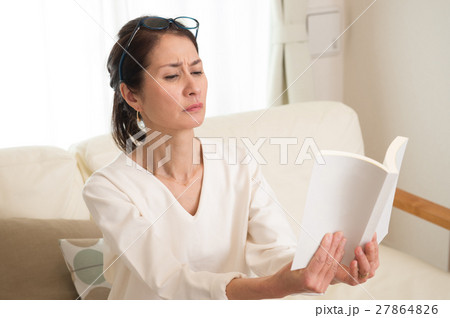 老眼鏡で読書する中年日本人女性 27864826