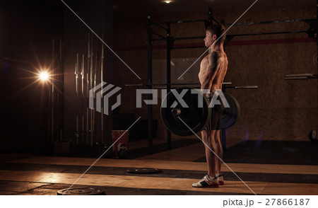 Young muscular man lifting barbell in gym Young muscular man lifting barbell in gym 27866187