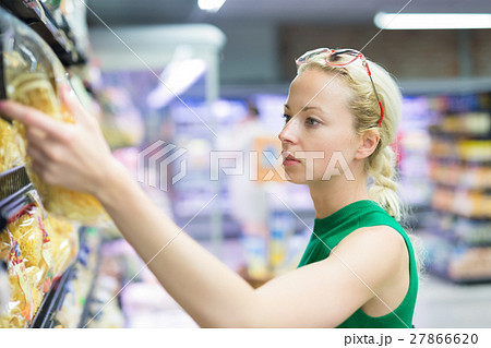 Woman shopping groceries at supermarket. 27866620