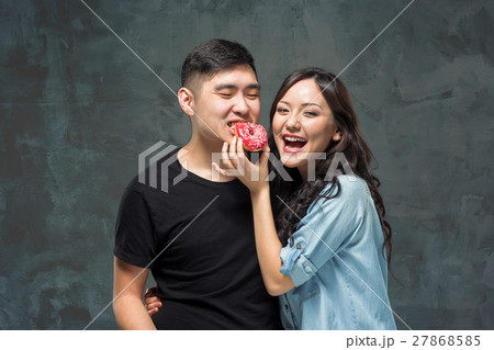 Young asian couple enjoy eating of sweet colorful Young asian couple enjoy eating of sweet colorful 27868585