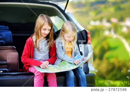 Two adorable little sisters exploring a map Two adorable little sisters exploring a map 27872596