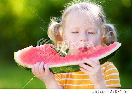 Funny little girl biting a slice of watermelon Funny little girl biting a slice of watermelon 27874452