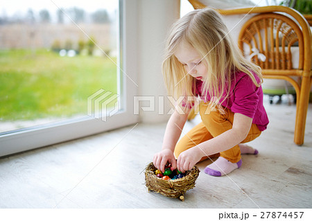 Cute little girl playing with colored Easter eggs Cute little girl playing with colored Easter eggs 27874457