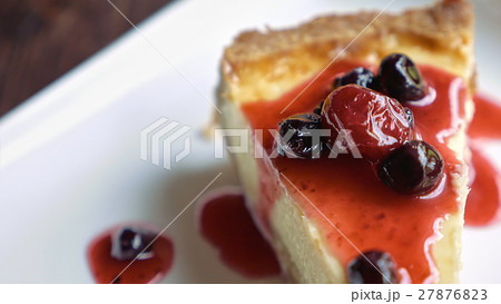 Cheesecake piece topped with fruit sauce Cheesecake piece topped with fruit sauce 27876823