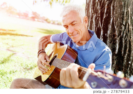 Senior man plying guitar outdoors 27879433