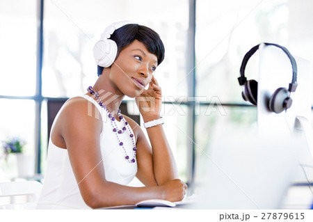 Young beautiful businesswoman listening music in headphones Young beautiful businesswoman listening music in headphones 27879615