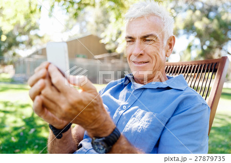 LoMature man outdoors using mobile phone 27879735