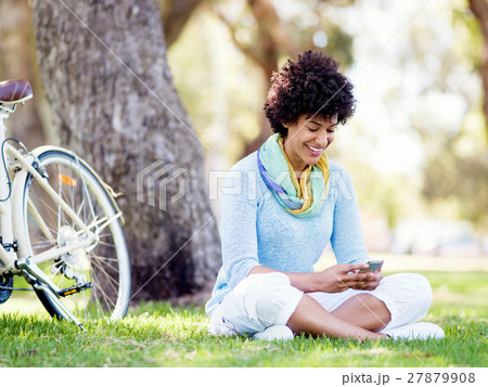 Charming young woman in summer park with mobile Charming young woman in summer park with mobile 27879908