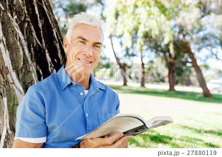 Senior man sittingin park while reading book 27880119