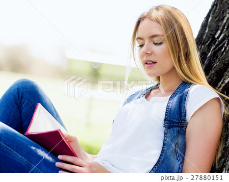 Beautiful young woman writing in her diary outdoors 27880151
