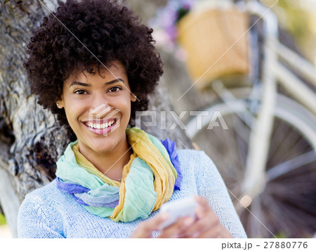 Charming young woman in summer park with mobile Charming young woman in summer park with mobile 27880776