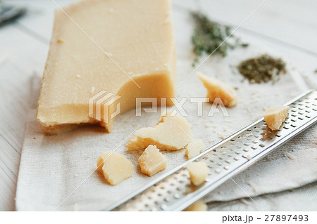Parmesan piece closeup with small grater Parmesan piece closeup with small grater 27897493