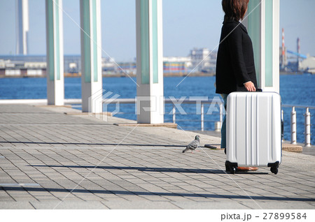 港でスーツケースを持つ女性旅行者 27899584
