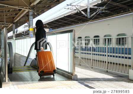 新幹線の駅でスーツケースを持つ女性旅行者 27899585