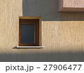 Old window with wooden frame on the yellow stucco 27906477